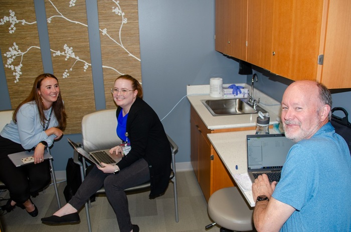 Students and clinicians in a medical exam room.