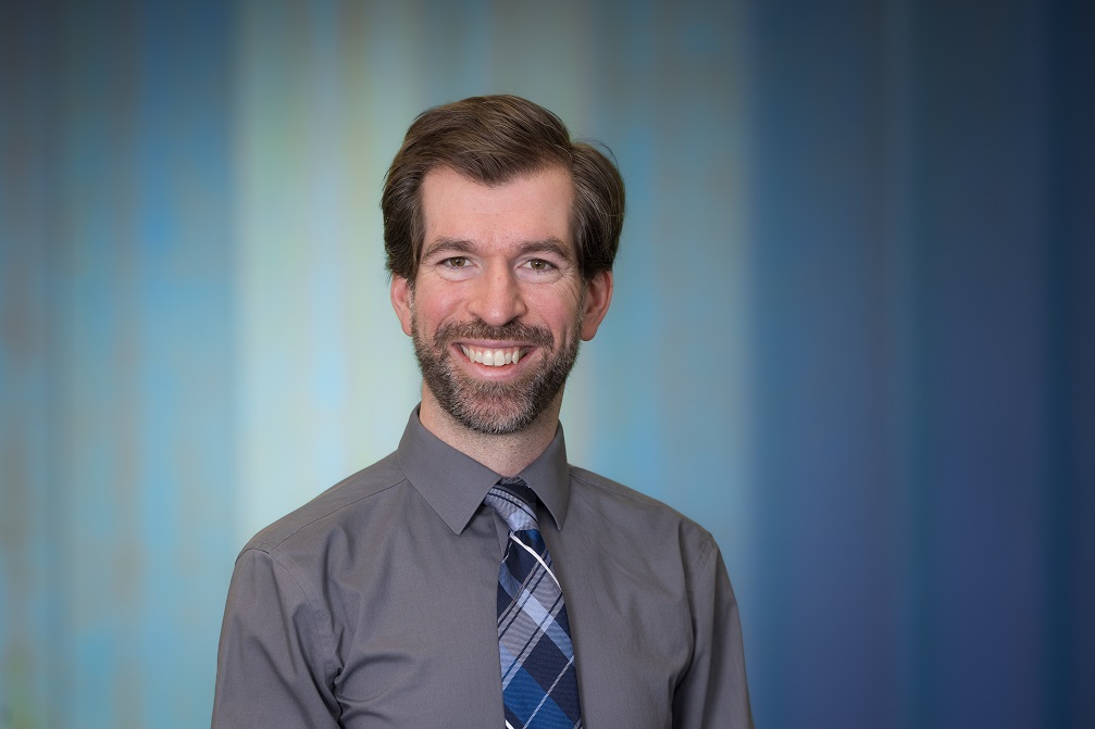 Photo of Dr. Ryan Marker with a blue background.