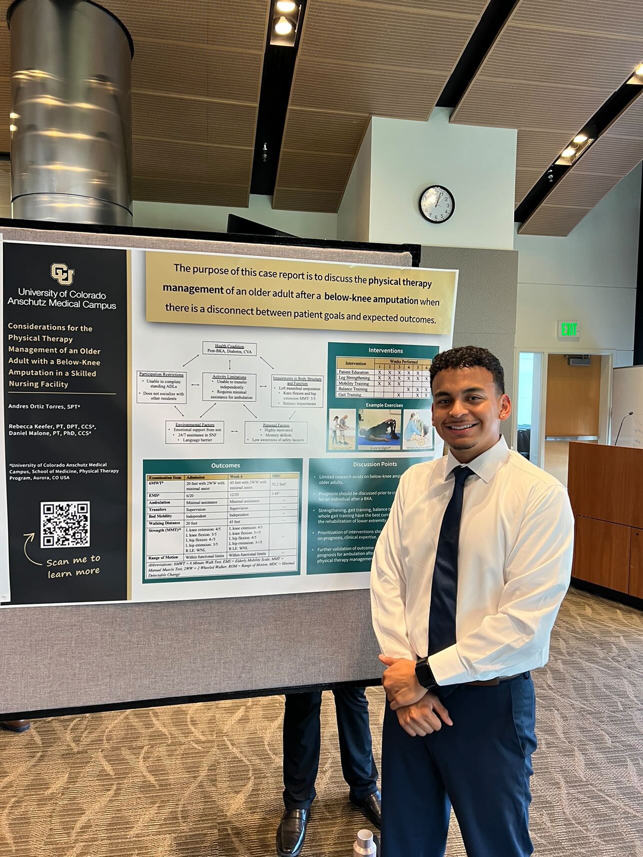 Photo of Andres Ortiz Torres standing next to his Capstone poster.