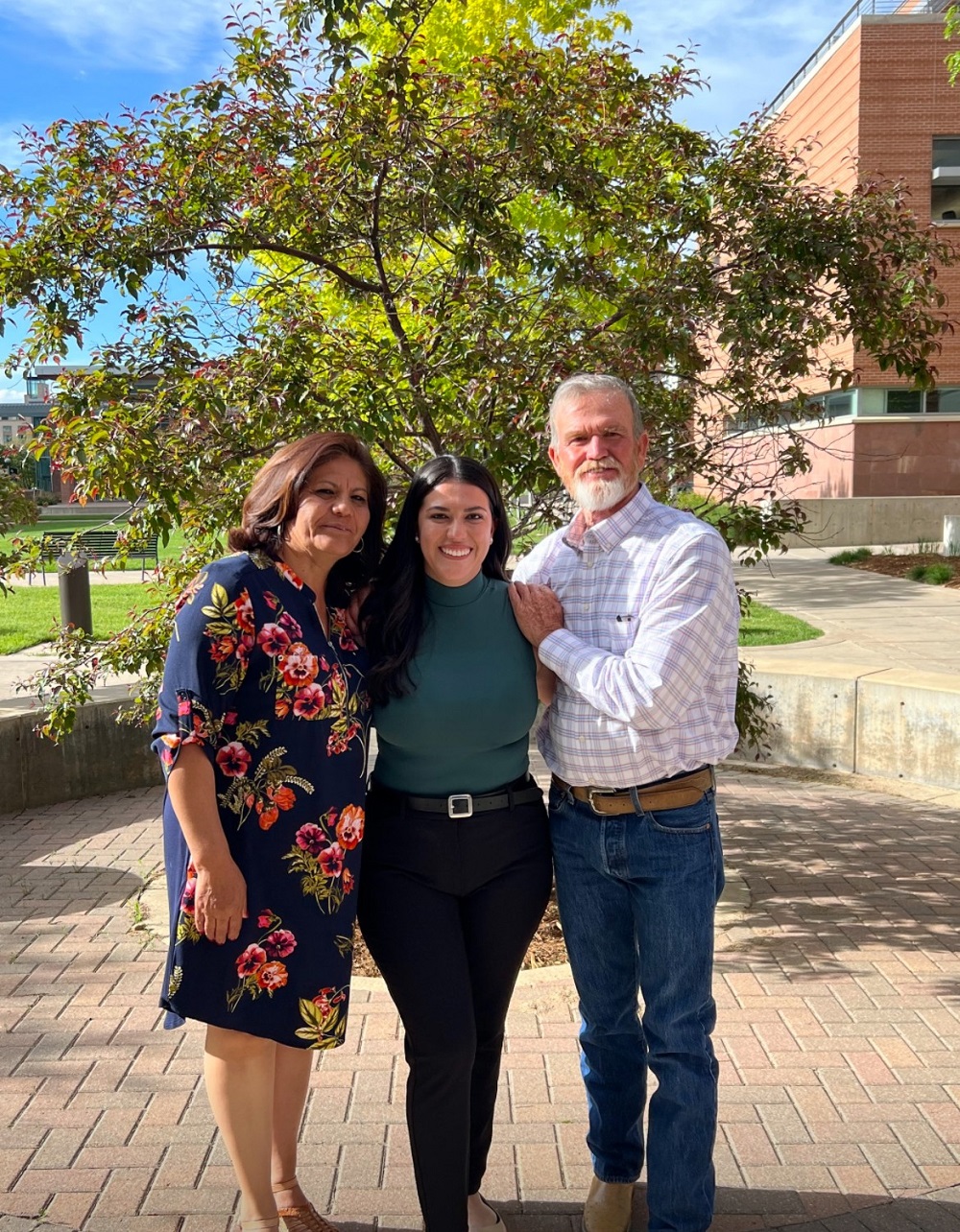 Photo of Cecilia Loya standing with two people next to Boettcher Commons on the CU Anschutz Medical Campus.