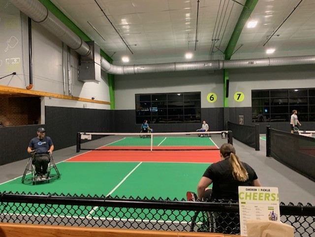 People playing pickleball in wheelchairs.