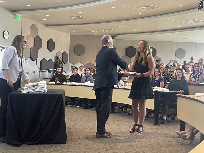 Photo of a young woman receiving her white coat at the 2026 Hybrid DPT Oath Ceremony.