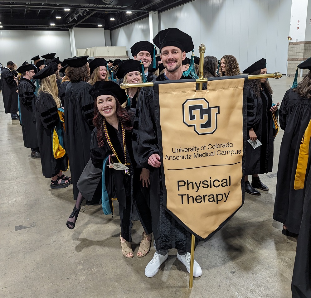 Photo of graduates carrying the PT Flag