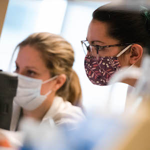Image of two women wearing masks working in a lab