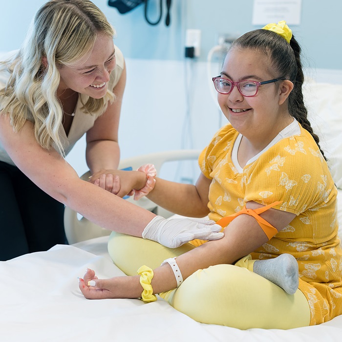 Girl with Down syndrome getting prepped for a blood draw