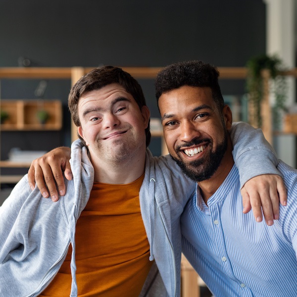 Image of man with arm around another man with Down syndrome