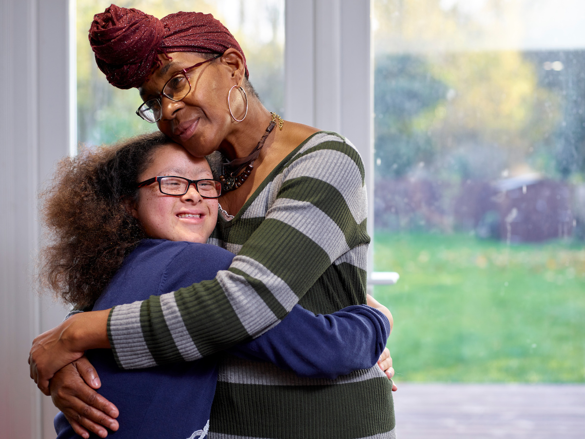 Stock image of woman hugging another woman with Down syndrome