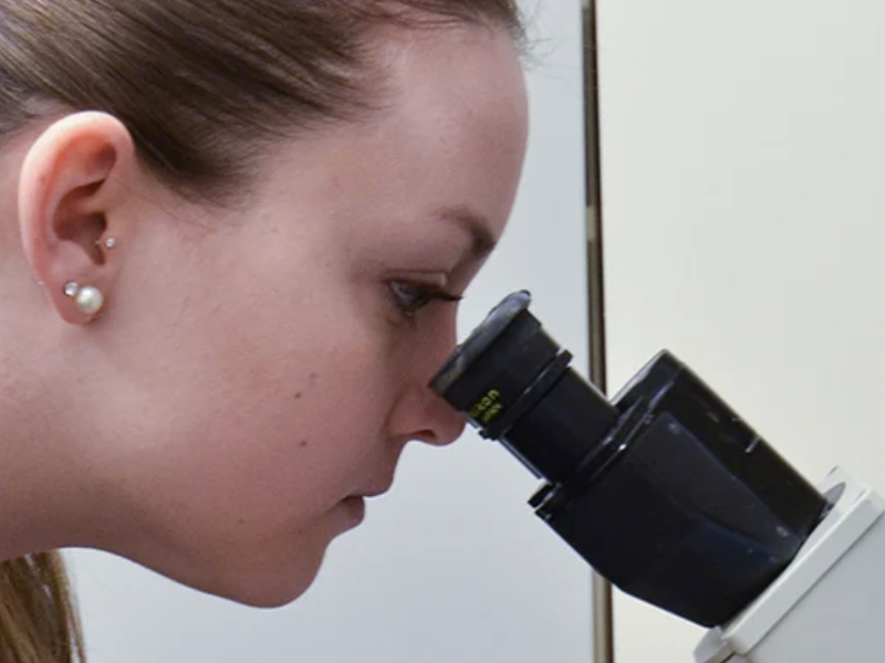 Image of scientist looking into microscope
