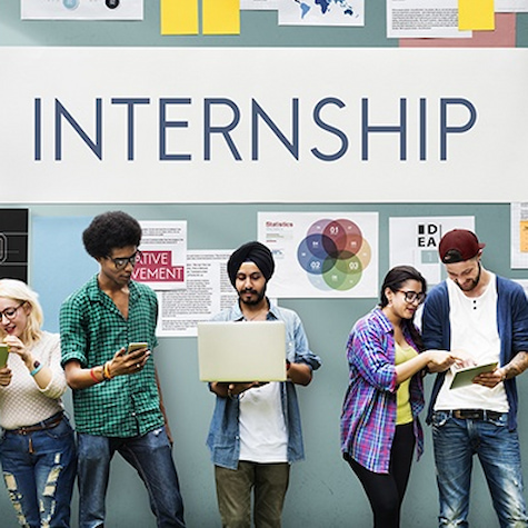 Interns sign with diverse students in front