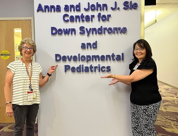Two women pointing to Developmental Pediatrics sign at Children's Hospital Colorado