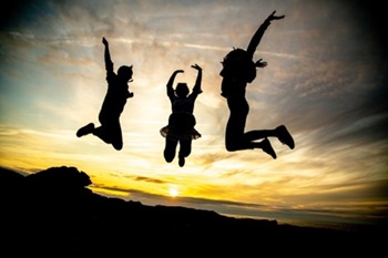 Silhouette of three people jumping